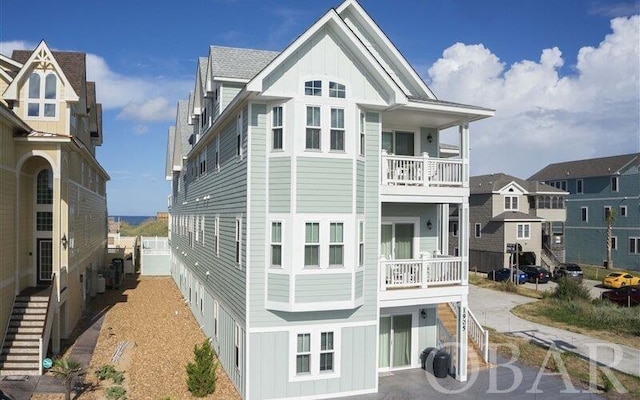 rear view of house with board and batten siding and a balcony