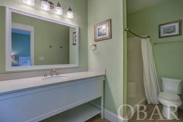 full bathroom featuring curtained shower, vanity, and toilet