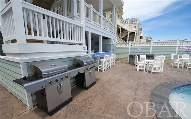 view of patio featuring outdoor dining space, a grill, and fence