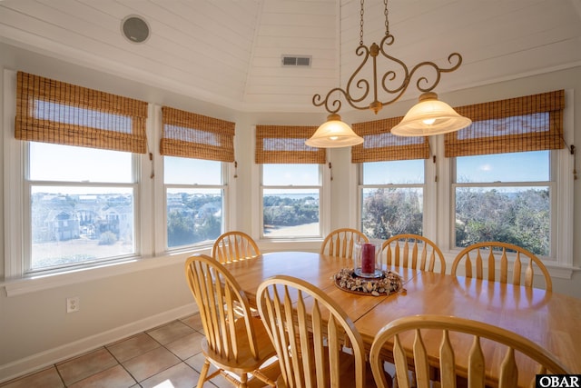 dining space with visible vents, baseboards, light tile patterned flooring, and a towering ceiling