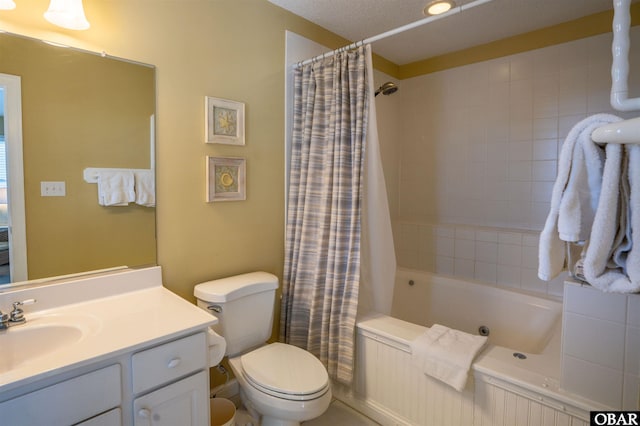 full bath featuring shower / tub combo with curtain, a textured ceiling, toilet, and vanity