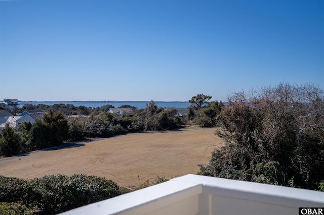 view of yard with a balcony and a water view