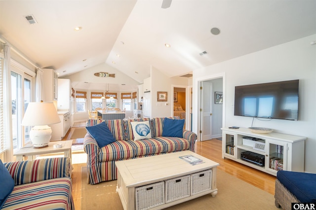 living room with recessed lighting, visible vents, lofted ceiling, and light wood finished floors