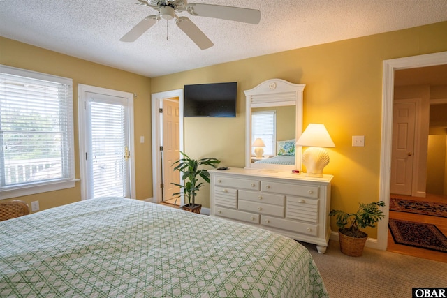 bedroom featuring ceiling fan, carpet, baseboards, and a textured ceiling