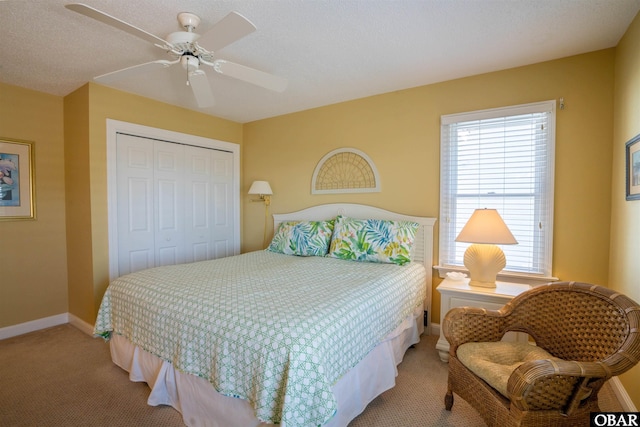 carpeted bedroom featuring a ceiling fan, baseboards, and a closet