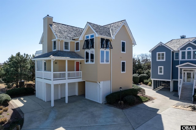 view of front of house with a chimney, driveway, and an attached garage