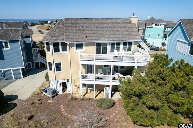 rear view of property featuring cooling unit and a chimney