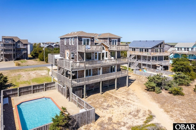 back of property with a fenced in pool, a residential view, and a fenced backyard