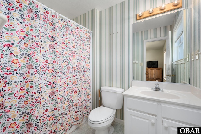 bathroom with baseboards, toilet, vanity, and wallpapered walls