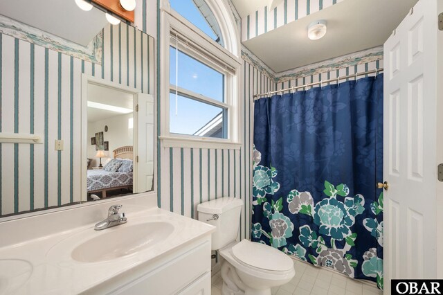 ensuite bathroom with vanity, a shower with shower curtain, wallpapered walls, ensuite bath, and toilet