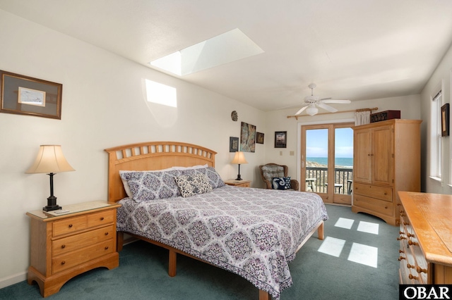 carpeted bedroom with access to exterior, a skylight, and ceiling fan