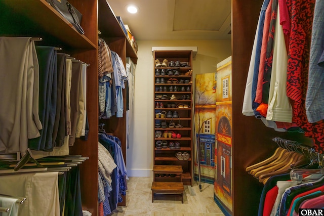spacious closet featuring attic access and light tile patterned floors