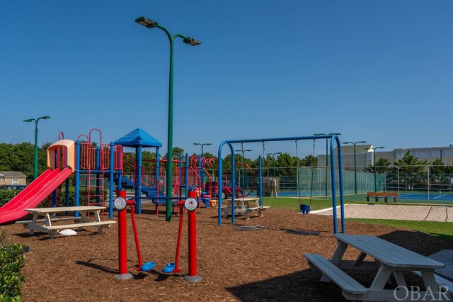 communal playground with a tennis court and fence