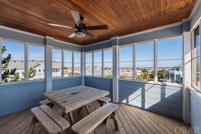 unfurnished sunroom with wood ceiling, a healthy amount of sunlight, and ceiling fan