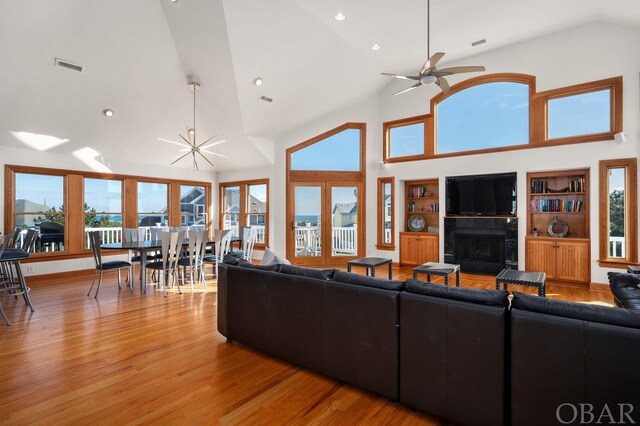 living area with light wood-style floors, plenty of natural light, a fireplace, and visible vents