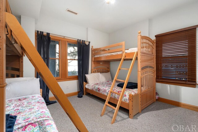 bedroom featuring visible vents, light carpet, and baseboards