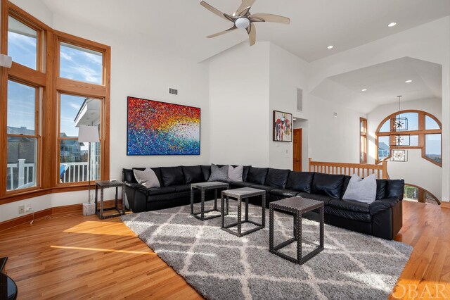 living room with high vaulted ceiling, wood finished floors, and visible vents