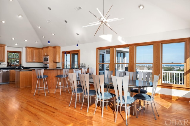 dining room featuring high vaulted ceiling, light wood-style flooring, recessed lighting, visible vents, and an inviting chandelier