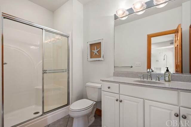 bathroom with toilet, tile patterned floors, a shower stall, and vanity