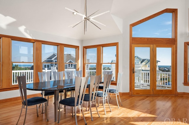 dining area featuring a chandelier, baseboards, and light wood-style floors