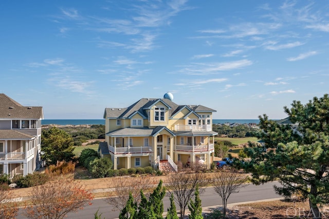 view of front of house featuring a water view and a balcony