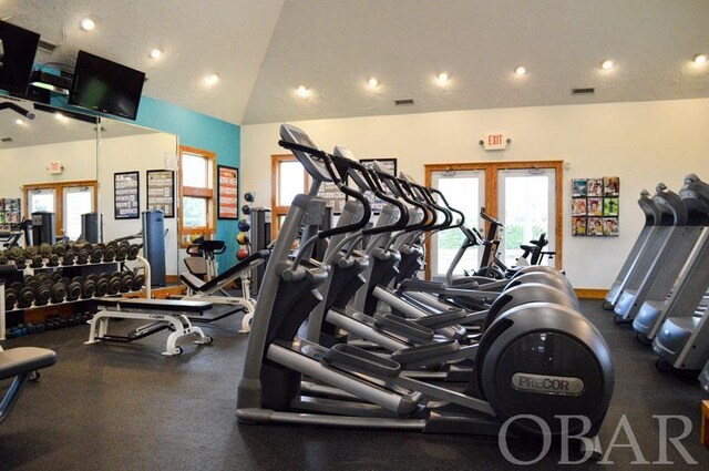 workout area with lofted ceiling, recessed lighting, visible vents, and french doors