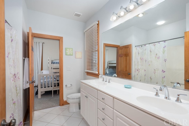 bathroom featuring double vanity, visible vents, a sink, and tile patterned floors