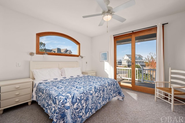 bedroom featuring access to outside, multiple windows, dark carpet, and ceiling fan