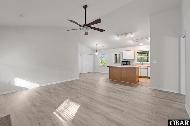 106 Mybet Ct Lot 97, Kill Devil Hills, NC 27948 - unfurnished living room with baseboards, ceiling fan, rail lighting, light wood-style floors, and high vaulted ceiling