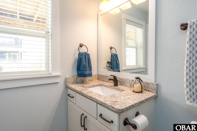 bathroom featuring vanity and a textured wall