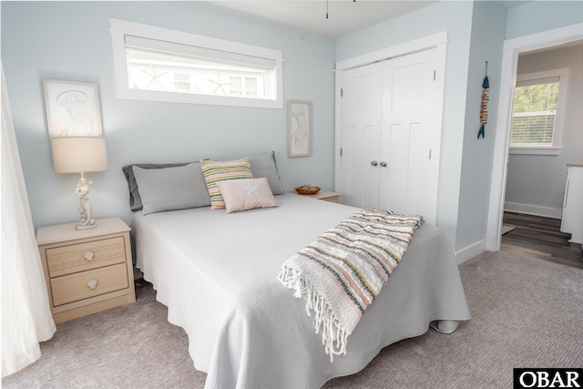 bedroom with carpet, baseboards, and a closet