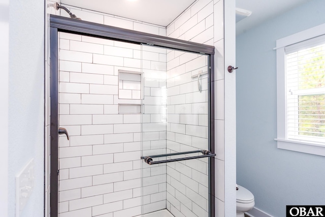 full bathroom featuring baseboards, toilet, and a stall shower