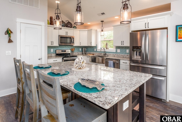 kitchen featuring tasteful backsplash, visible vents, appliances with stainless steel finishes, and a sink