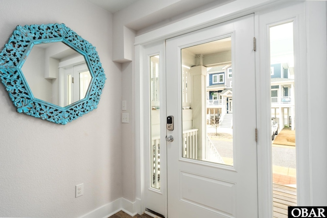 foyer featuring plenty of natural light and baseboards