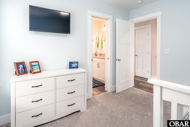 bedroom featuring light carpet and connected bathroom