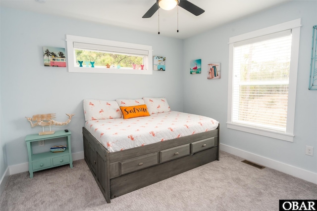 bedroom featuring multiple windows, baseboards, visible vents, and light carpet