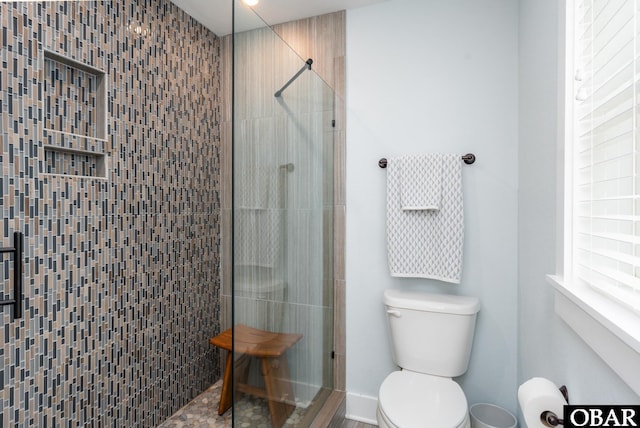 bathroom featuring toilet and a stall shower