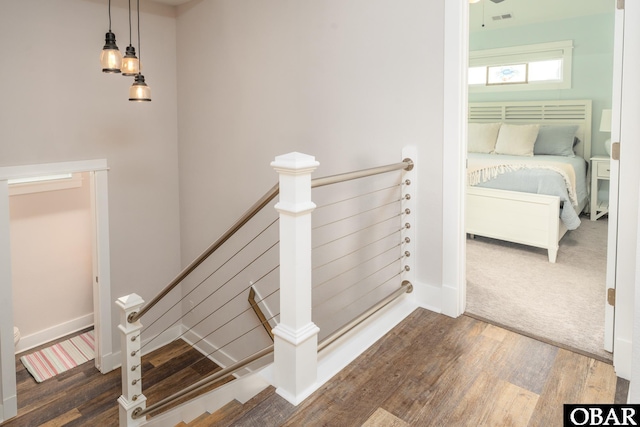 stairs featuring wood finished floors, visible vents, and baseboards