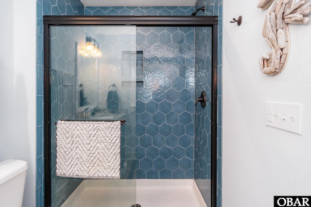 bathroom with a shower stall and toilet