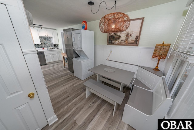 807 S St Lot 11, Manteo, NC 27954 - dining room featuring stacked washer and dryer, wainscoting, and light wood-style flooring