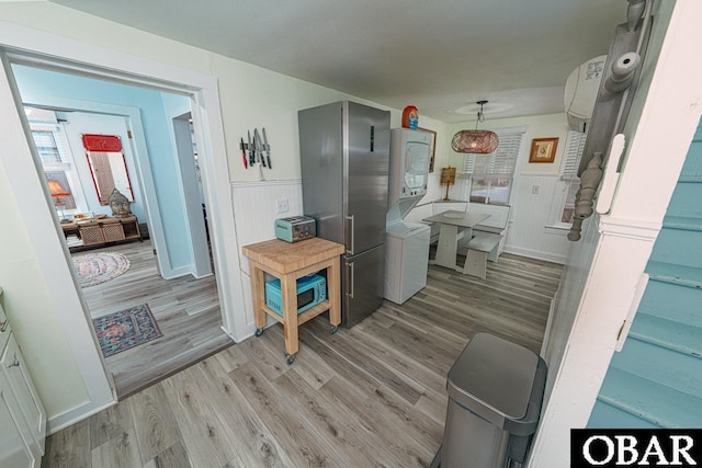 807 S St Lot 11, Manteo, NC 27954 - hall with washer / dryer, a wainscoted wall, a wall unit AC, and light wood-style flooring