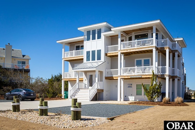 raised beach house with a standing seam roof, metal roof, and board and batten siding