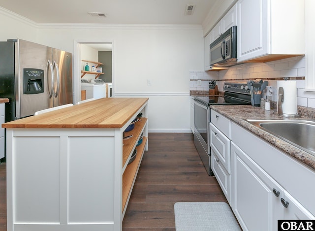 kitchen with separate washer and dryer, butcher block counters, visible vents, white cabinets, and appliances with stainless steel finishes