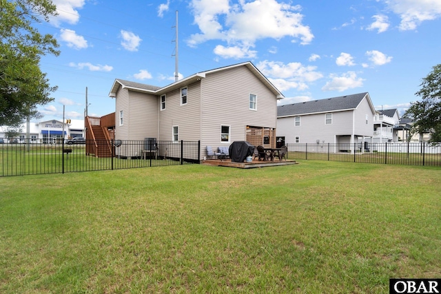 rear view of property featuring a fenced backyard, a wooden deck, and a yard