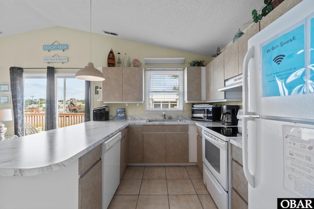 kitchen featuring white appliances, a peninsula, lofted ceiling, and light countertops