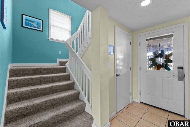 foyer entrance featuring recessed lighting, baseboards, stairs, and light tile patterned floors