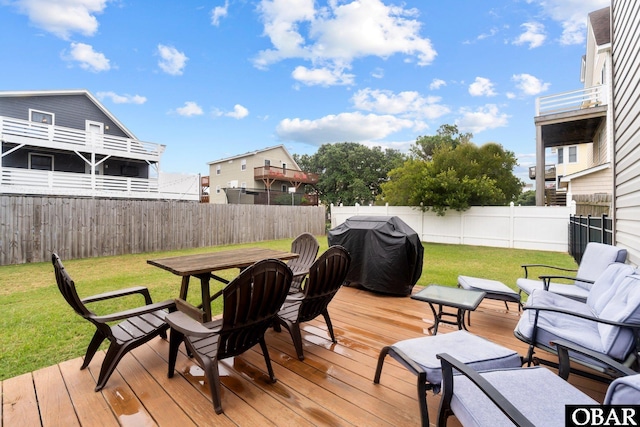 wooden deck featuring a fenced backyard, a yard, and grilling area