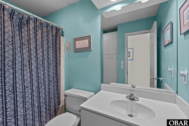 bathroom featuring vanity, a textured ceiling, toilet, and curtained shower