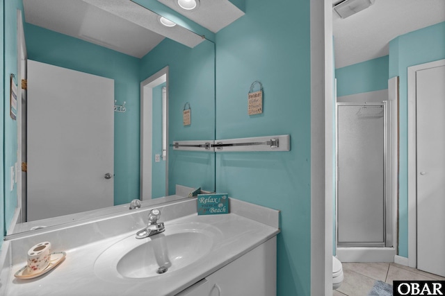 full bathroom featuring tile patterned flooring, a stall shower, toilet, and vanity