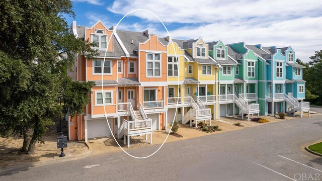 view of property featuring a residential view, an attached garage, and stairs